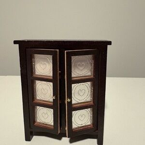 Small Dark Brown Wooden Cabinet with Heart-Patterned Panels